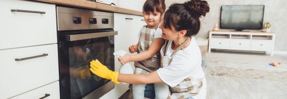 Una hija y su madre limpiando la cocina