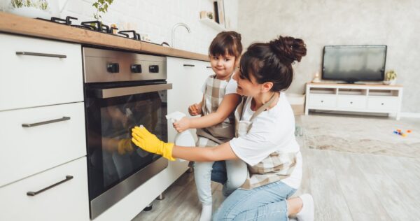 Una hija y su madre limpiando la cocina